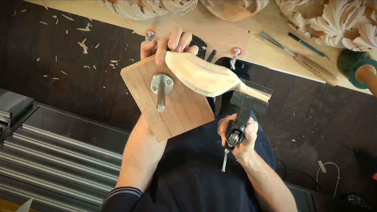 Block lifted out, its round Veritas plate sitting near one edge, the piece still clamped in the small vise