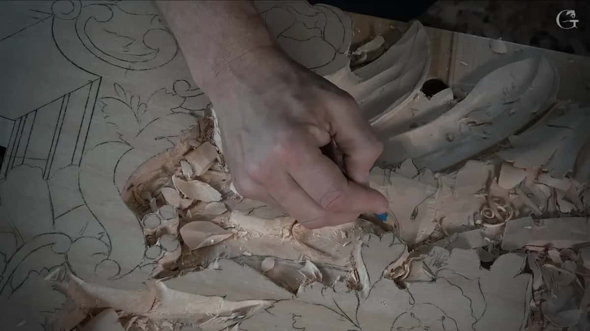 Hand drawing new lines with a blue pencil among fresh chips on the lower leaves