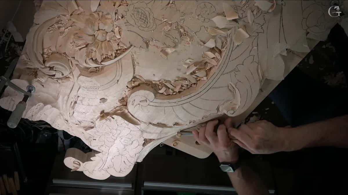 Panel seen from above with a clamp at the left and both hands working the bottom edge