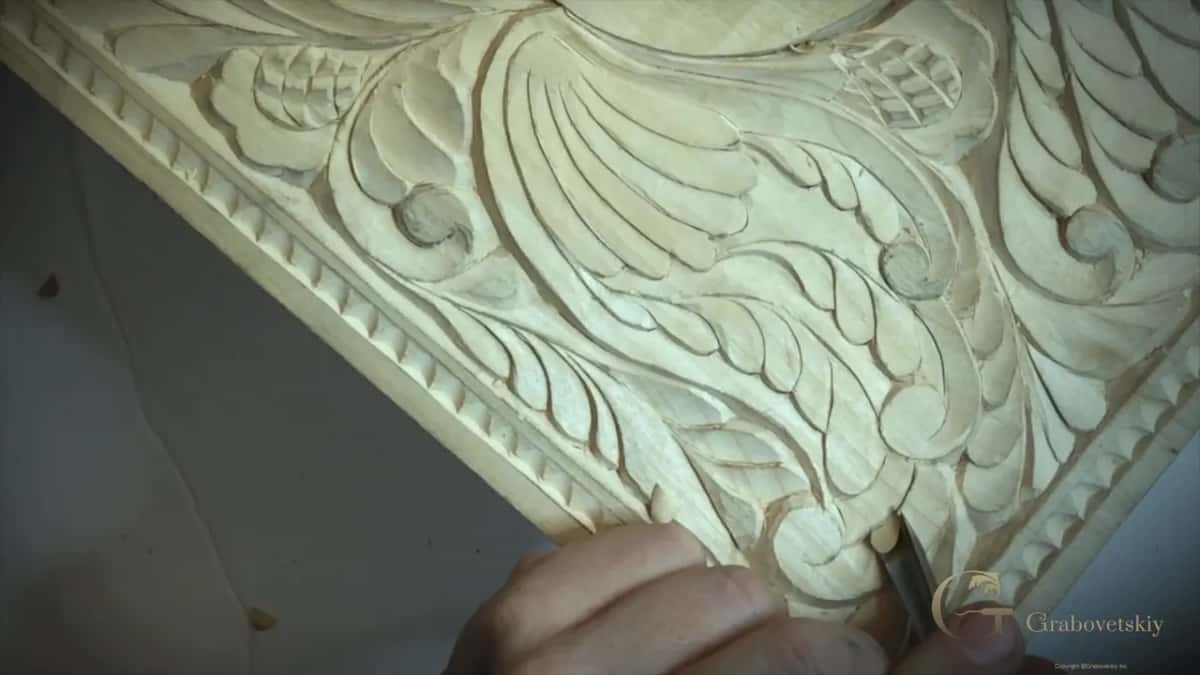 Raking light across the finished scalloped border, each gouge cut throwing its own small shadow along the frame.