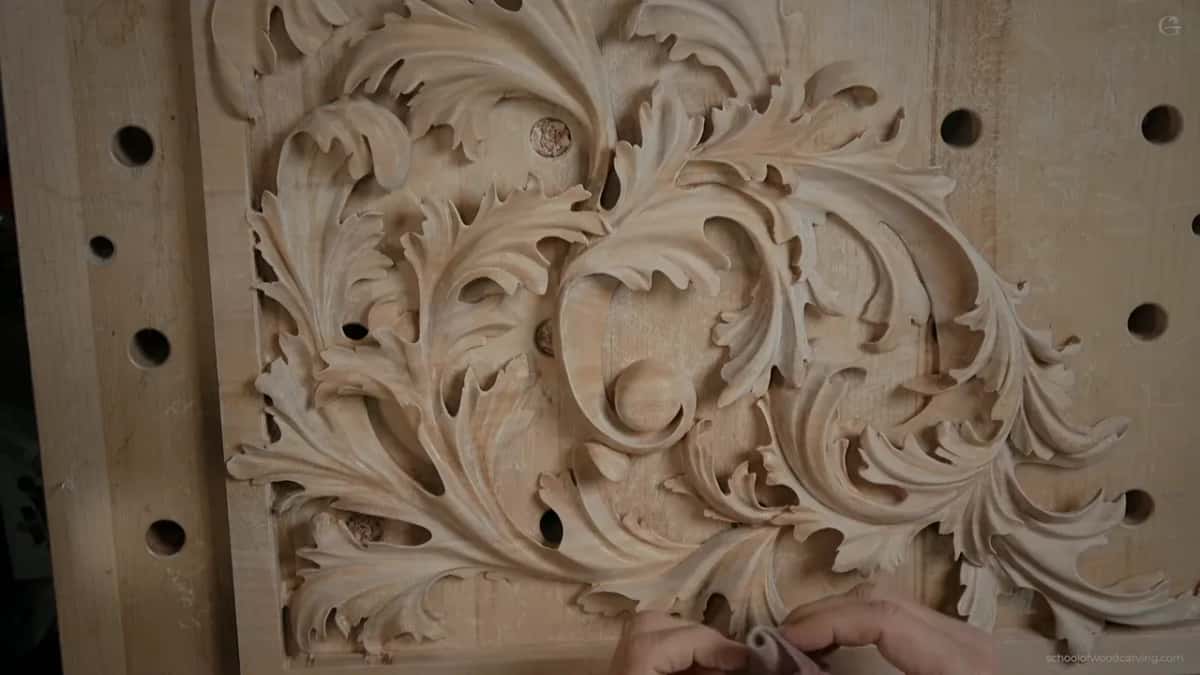 Overhead view of the pierced acanthus organ panel, with a folded pad of abrasive mesh in hand