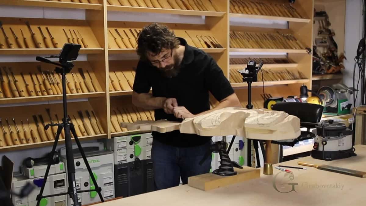 Alexander works a roughed panel held in a bench vise