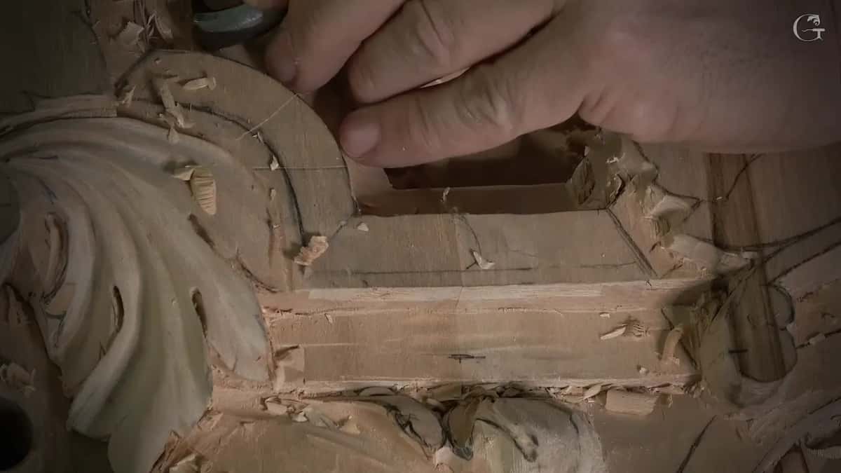 Fingertips steady a small tool against the drawn curve