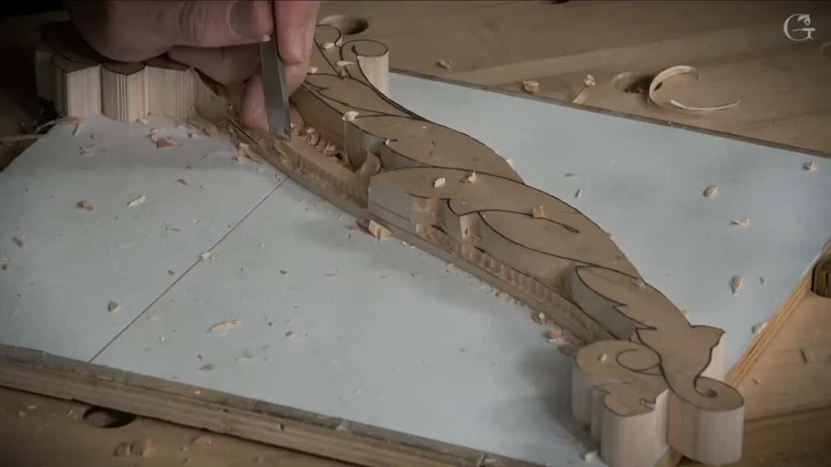Right on the pencil line, a narrow tool held upright beside a volute