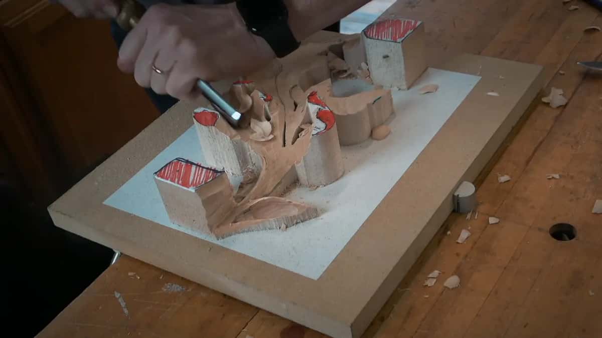 Big gouge scooping into the next section, one hand flat on the blank beside it