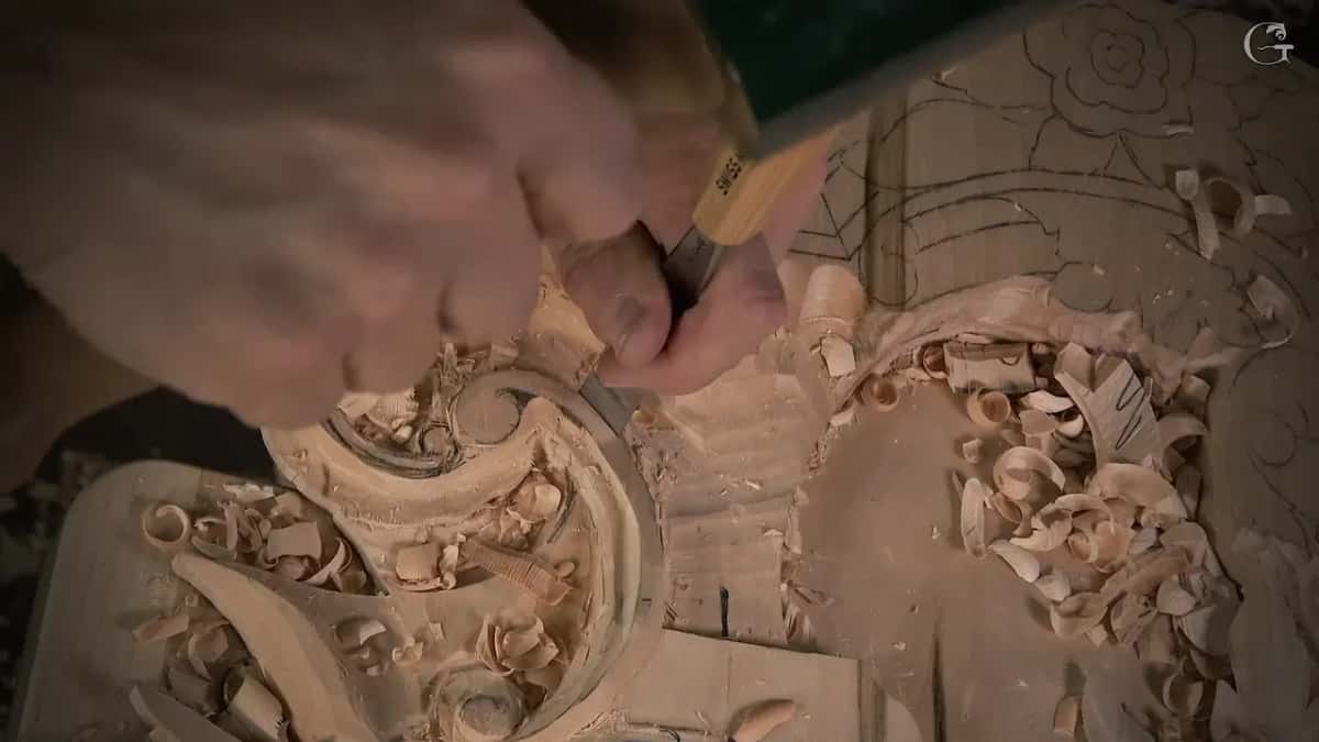 His hand wraps the handle while the blade sits against the scroll