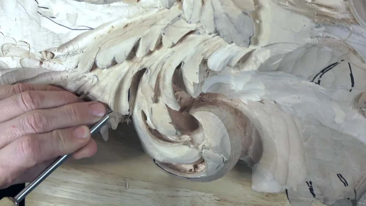 Under a big acanthus scroll, a narrow tool