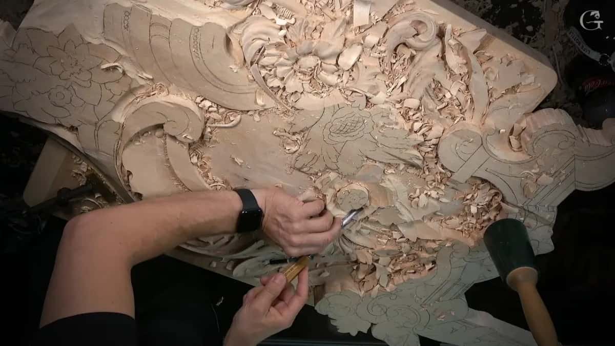 Two hands on a gouge inside a crowded flower panel