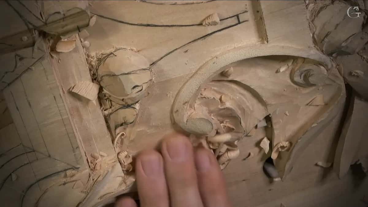 Fingertips rest on the scroll