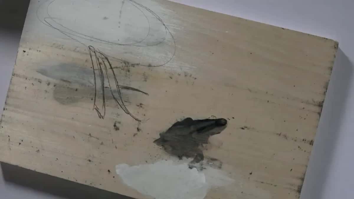 Pencil letter drawn with two lines per stroke on a painted practice board