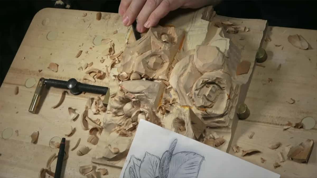 Seen straight from above, a gouge works the top while chips pile around the screw clamp