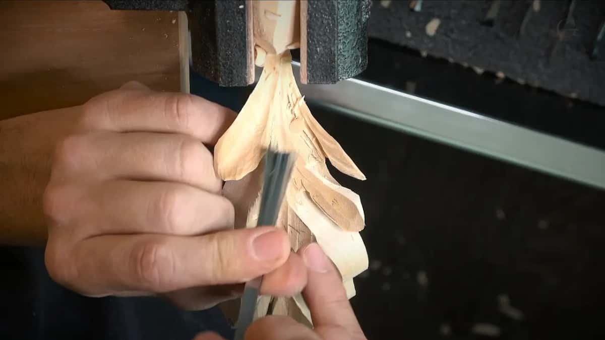 Held in a vise, a carved leaf takes a gouge along its side