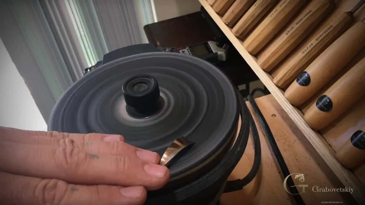 Steel edge held to a spinning wheel beside the gouge shelf
