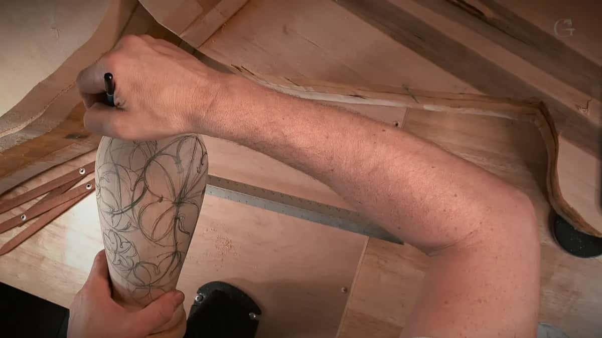 An arm reaches over the vase, its leaf layout drawn across the front