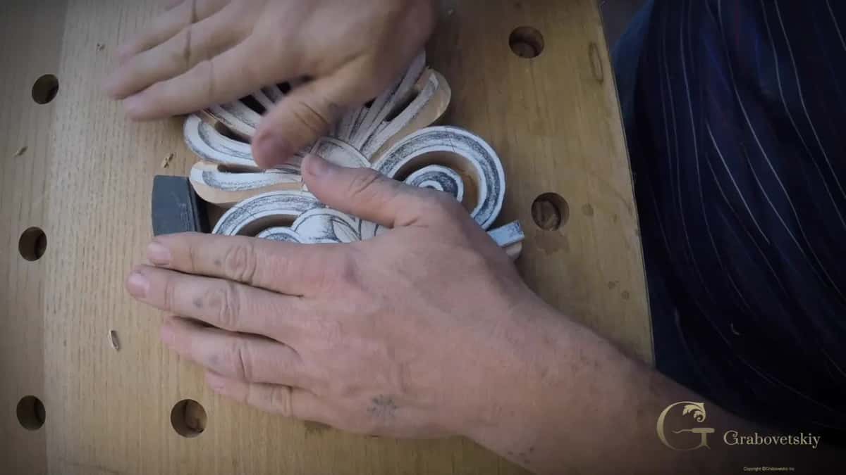 Two hands press the white palmette against one dark stop.
