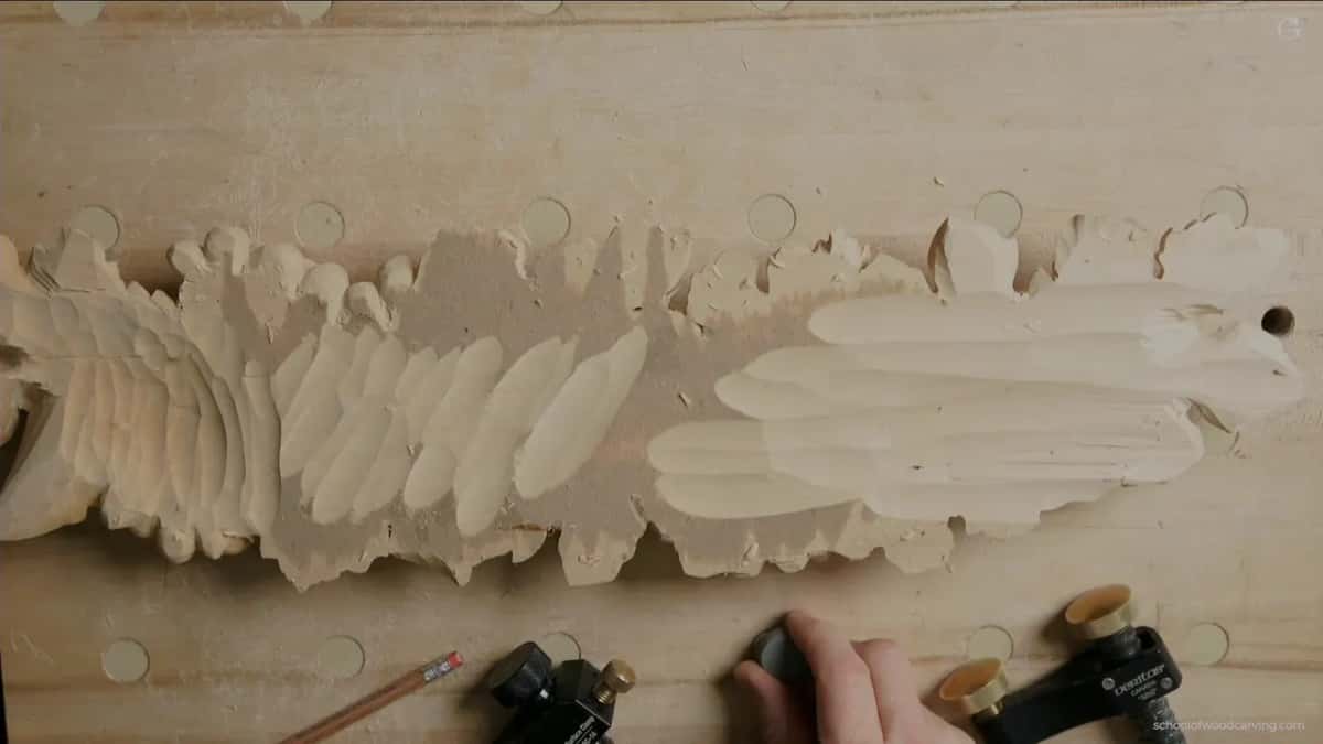 Roughed grape onlay on a board whose holes are plugged, two black clamps going on at the lower edge.