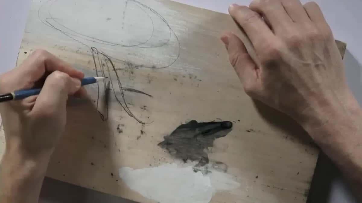 Pencil sketching a letter on scrap