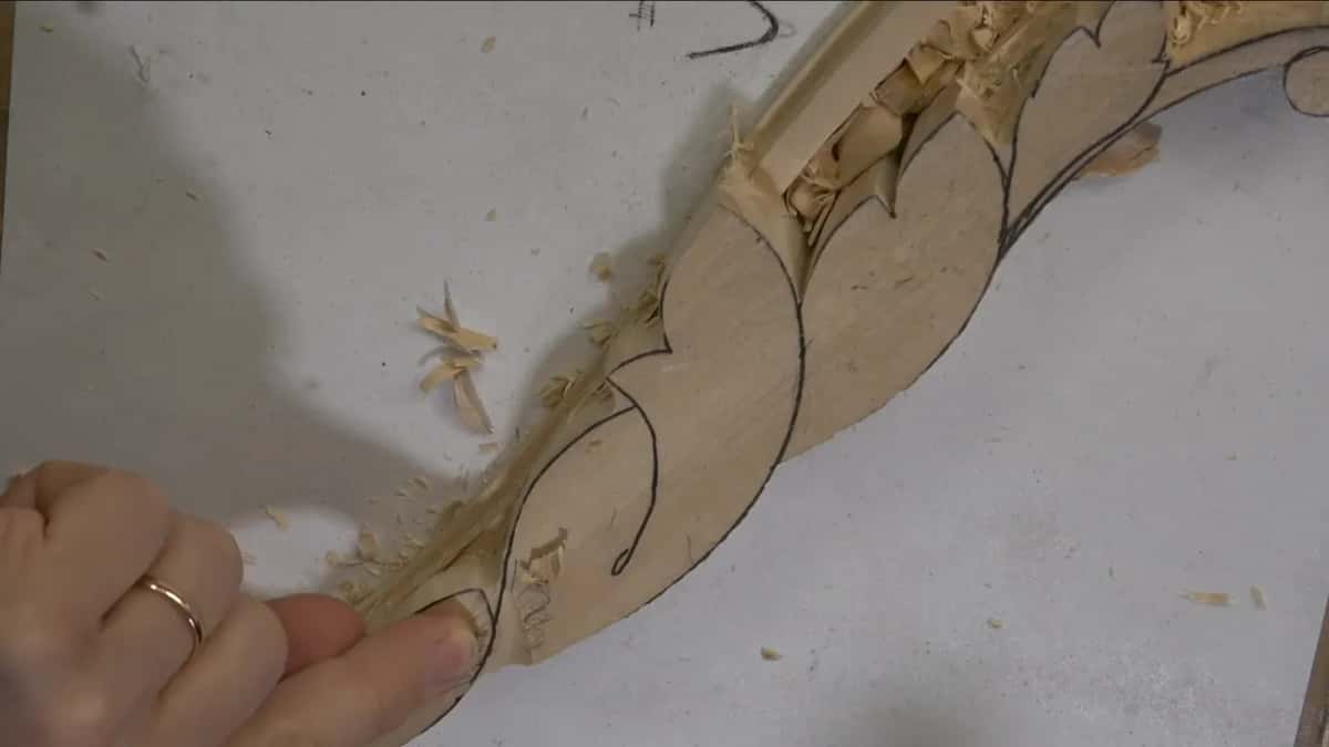 Shavings along a scrolled molding, a thumb at its tip