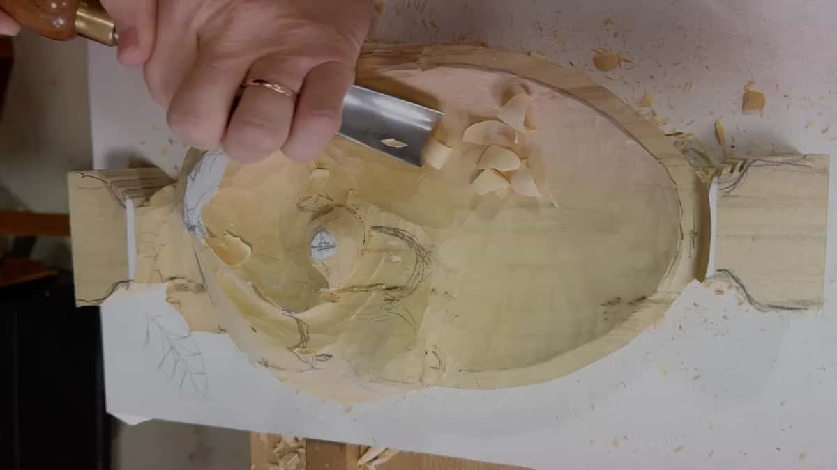Whole tray seen from above, a broad gouge in hand at the leaf end
