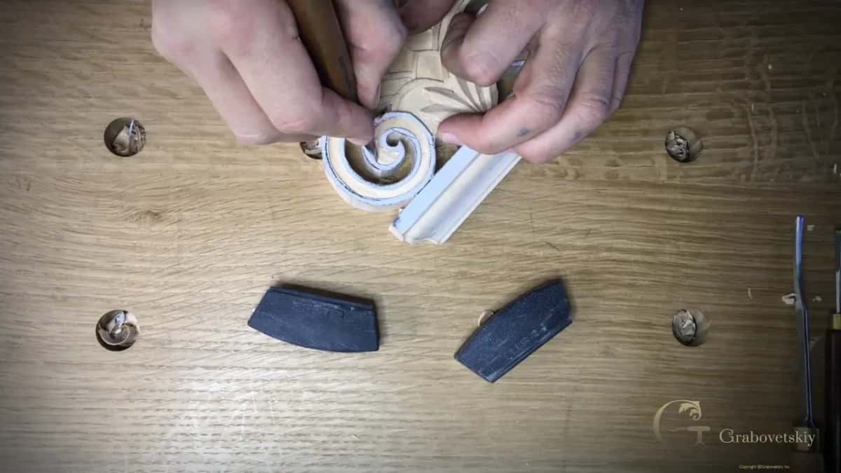 Both hands meet over the left spiral with the knife held between them