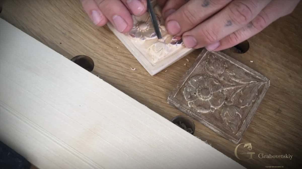 Working one small flower as the old piece lies to the right on the bench