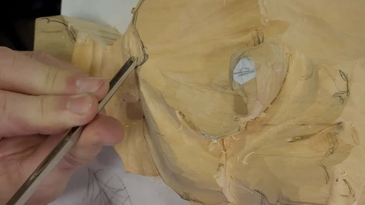Fingers pinch a narrow gouge at the seam where the leaf meets the ribbed block