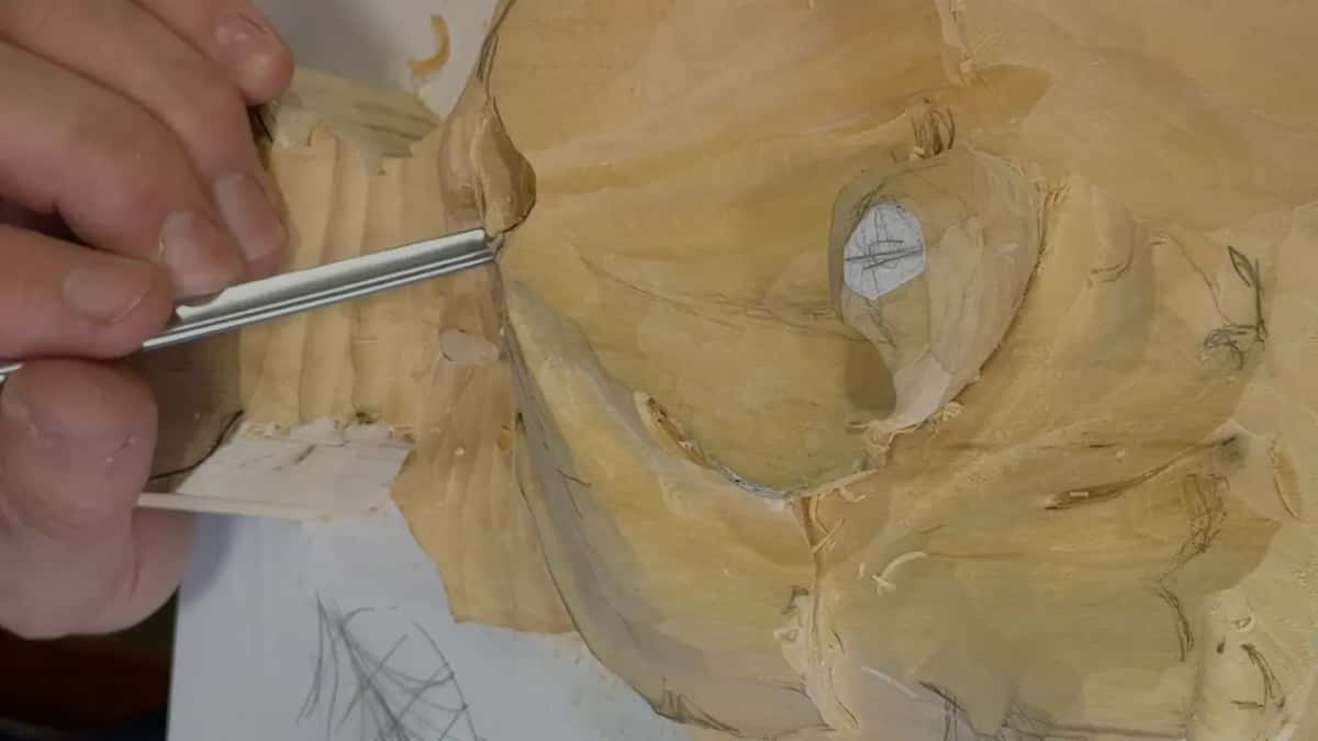Gouge laid almost flat, tip under the leaf edge