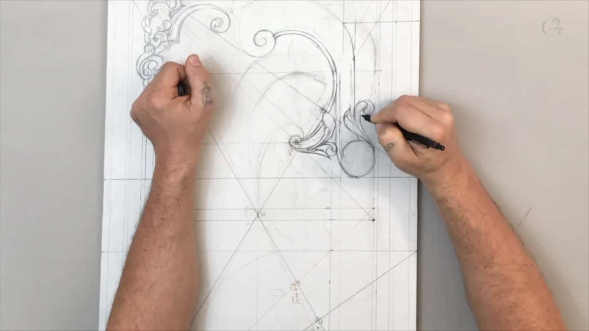Both hands on the sheet while the pen draws a small leaf beside the circle
