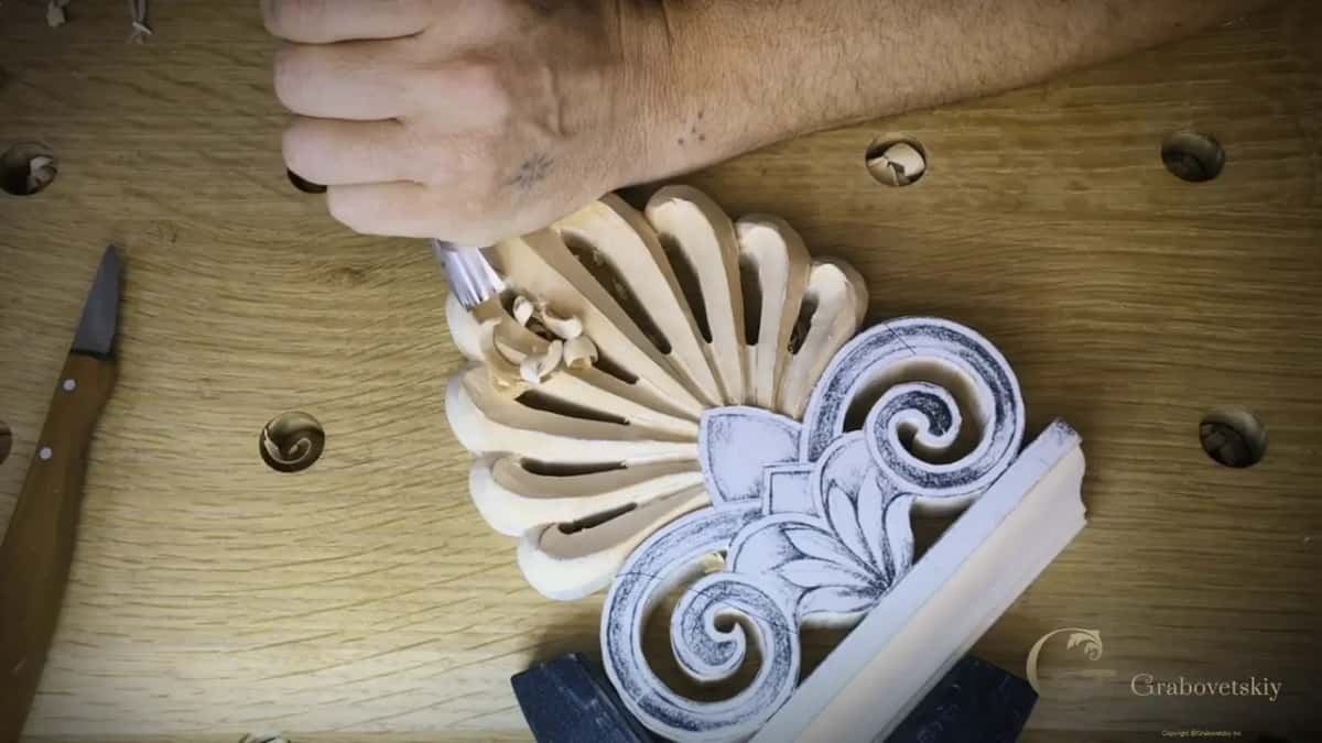 Gouge set at the base of the fan, a knife waiting on the bench
