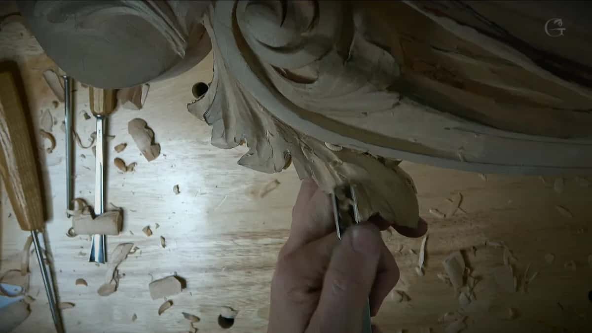 Working up under a leaf from below, tools scattered on the bench