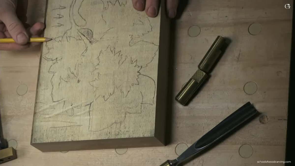 Grain arrows penciled at one corner while a bronze stop and a gouge wait nearby on the bench