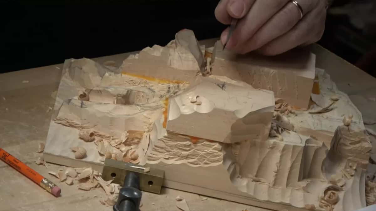 Fingertips drawing a narrow blade over the top