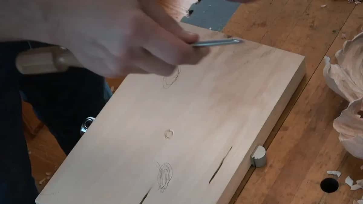 Long gouge held above the bare board