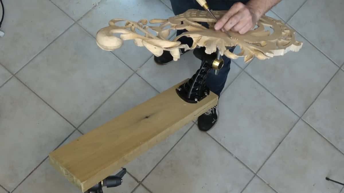 Pierced flower work on a black vise, the long board under it clamped down
