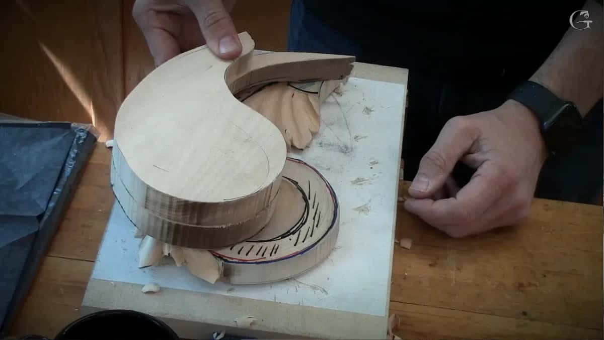 Lifting a curved top layer off the stack shows a circle drawn in red and black underneath.