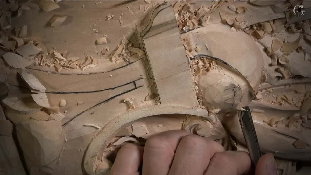 Tool tip working along the rim of that round shape while a hand steadies it from below