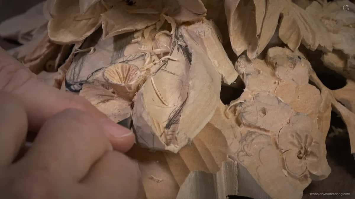 Pencil lines still on a carved bloom as the tool works in close.