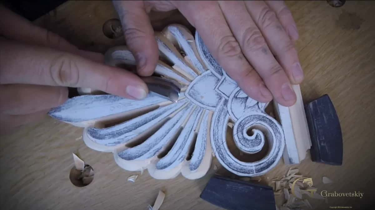 Both hands work a gouge between the petals near the middle of the fan