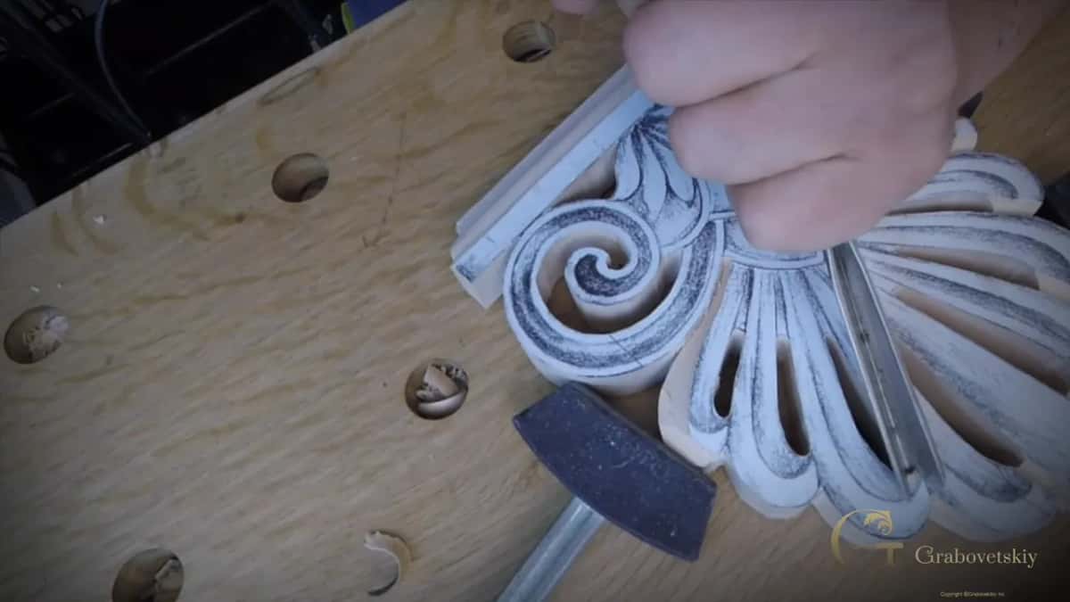 V tool held at the edge of the fan with a mallet lying just below