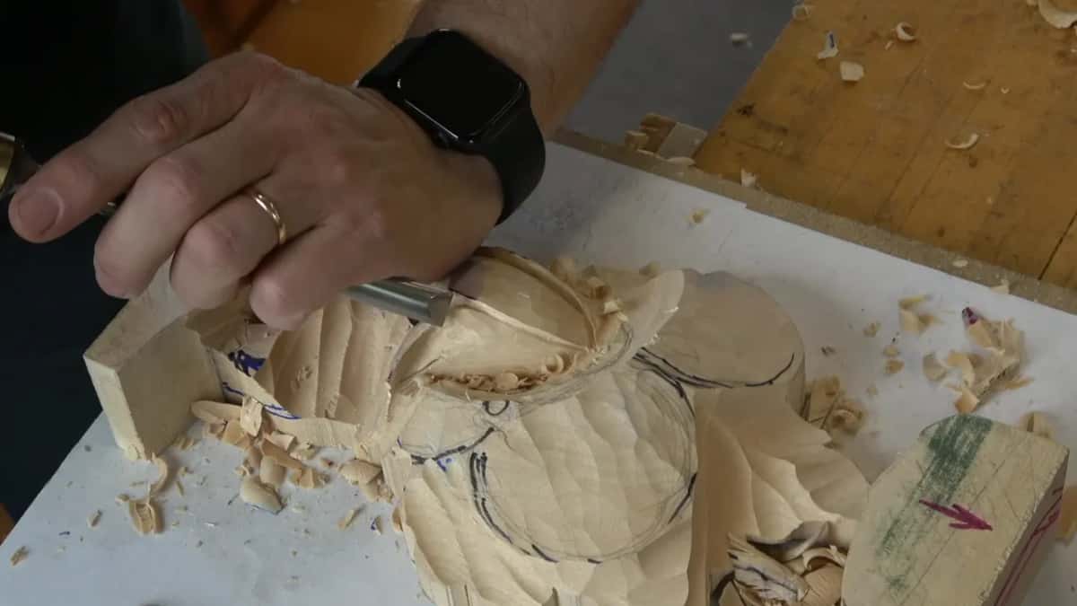 Fingers wrapped around a gouge handle, roughing a hollow, shavings everywhere.