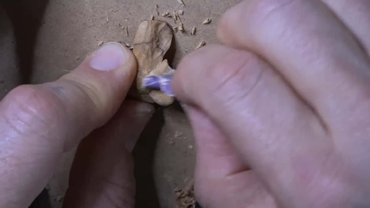 Fingertips sanding a flower.