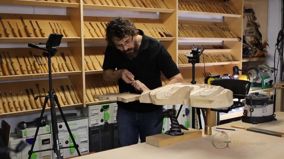 Wide view of the carver at work on a big pale scroll