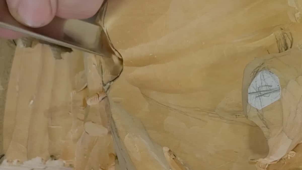Close in, a wide blade set against the edge beside the joint