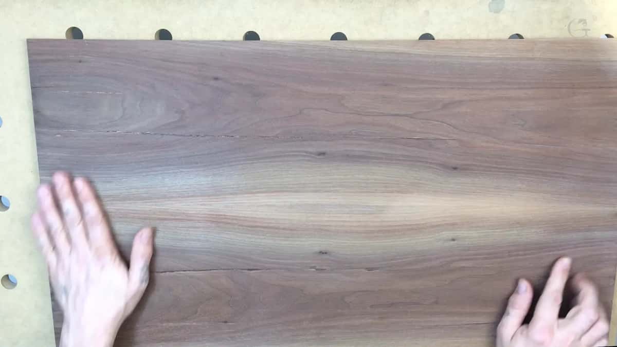 Walnut board, one hand at each end.