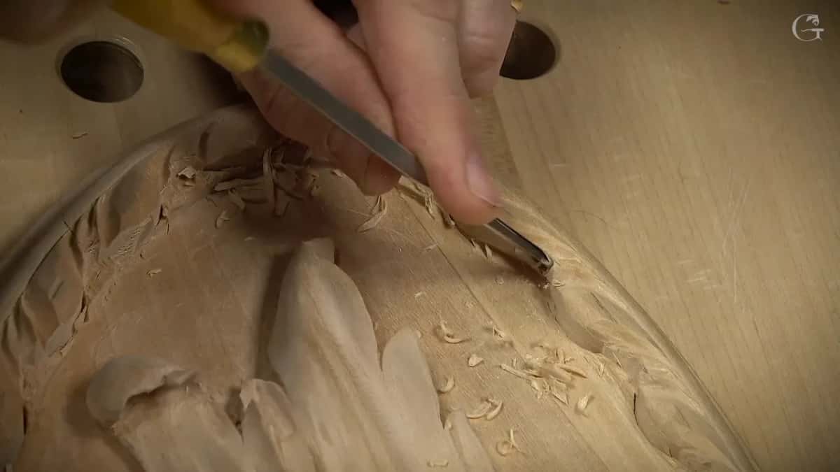 A yellow-handled gouge angled steeply down into the border