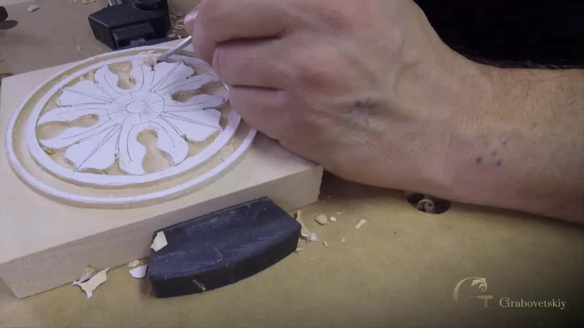 A small tool trims a rosette clamped flat on the bench