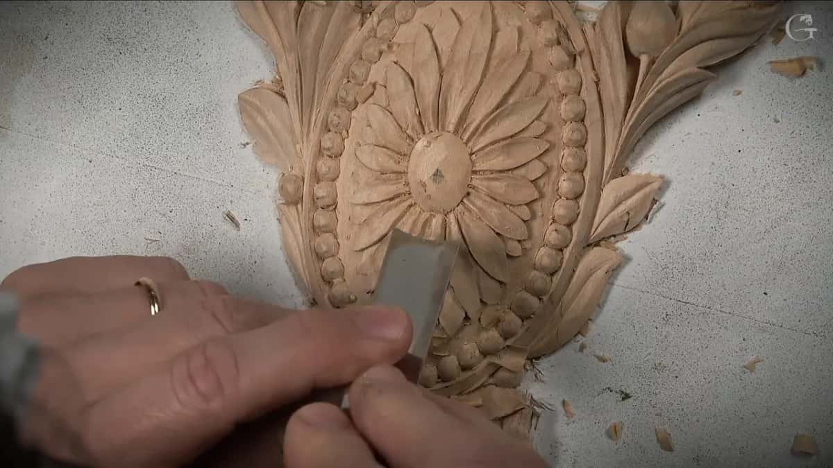 Flat steel low on the petals, the domed middle just above it, chips scattered on the board