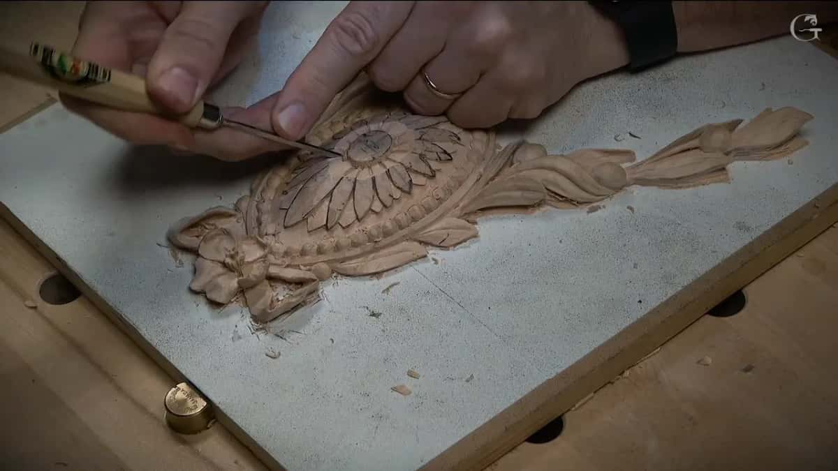 Seen from the side, a palm tool with a green label pushes in toward the middle of the flower