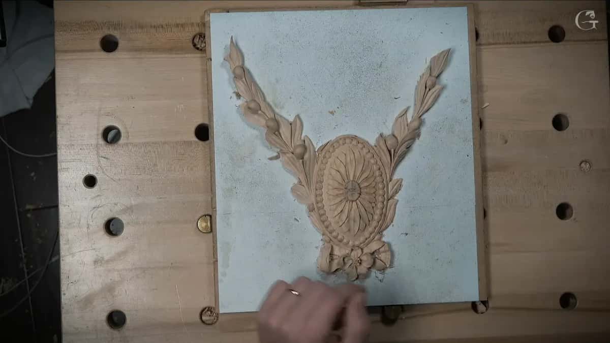 From above, the whole rosette on its blue board with every petal carved