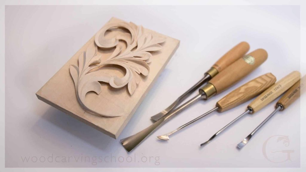 A beautifully carved wood panel featuring an elegant floral design is showcased alongside a set of high-quality carving tools. The tools, made with sturdy wooden handles, include a variety of chisels perfect for detailed woodwork. This image highlights the joy of creativity found in wood carving classes and lessons, perfect for anyone looking to explore their artistic side.